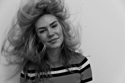 Portrait of beautiful woman against wall