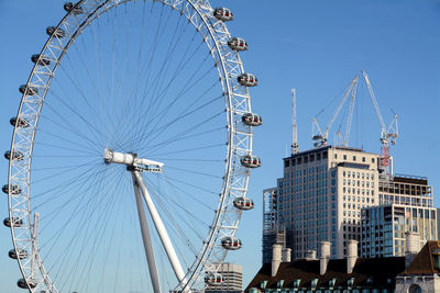 Low angle view of ferris wheel against blue sky