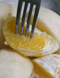 Close up view of fork picking up slice of orange