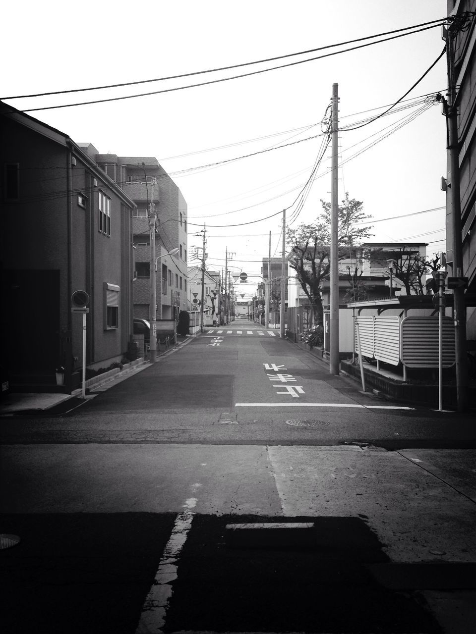 the way forward, architecture, building exterior, built structure, transportation, clear sky, diminishing perspective, street, road, city, road marking, vanishing point, empty, street light, sky, long, car, power line, building, incidental people