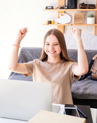 Portrait of a smiling young woman using phone