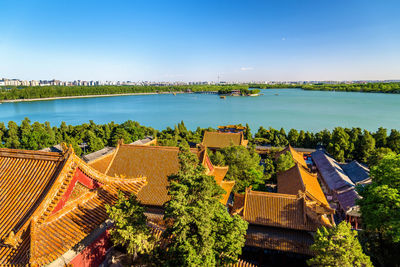 High angle view of townscape by lake against clear sky