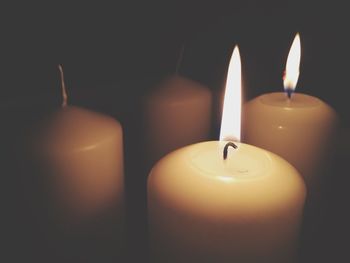 Close-up of lit candles in darkroom