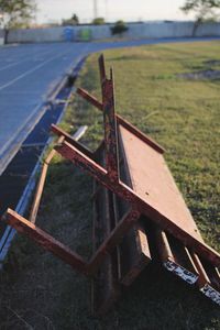 Close-up of rusty metallic bench on field