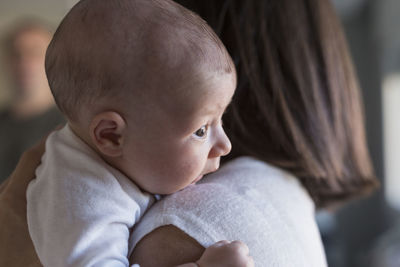 Side view of woman holding daughter at home