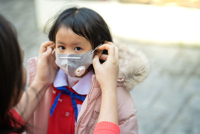 Schoolgirl wearing n95 mask to prevent deadly virus and air pollution.
