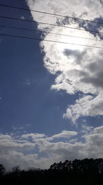 Low angle view of silhouette trees against sky