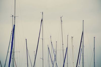 Sailboats moored in sea against clear sky