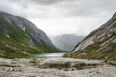 Scenic view of river and mountains against sky