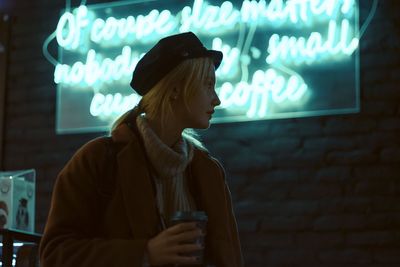 Midsection of woman standing by illuminated lights