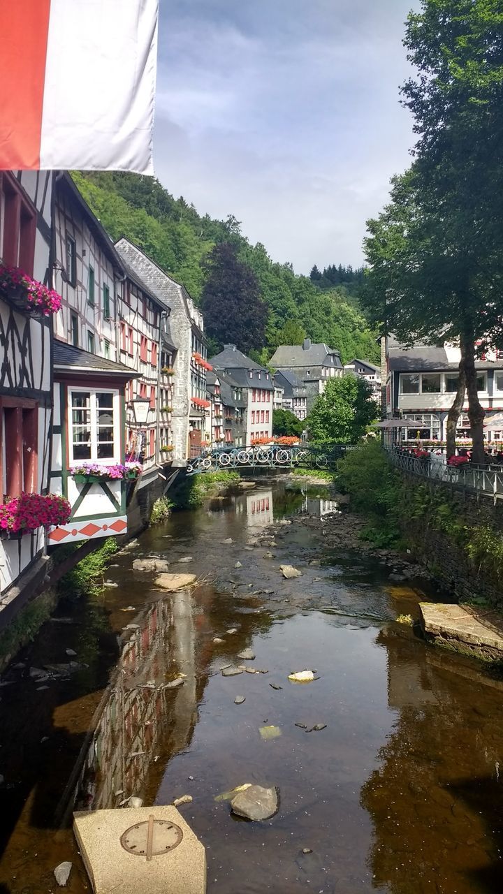 BUILDINGS BY RIVER AGAINST SKY
