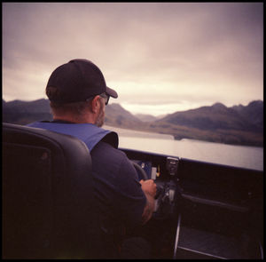 Rear view of man looking at sea against sky