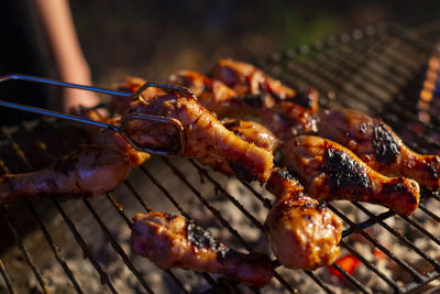 Organic chicken drumsticks are grilled on a barbecue grill