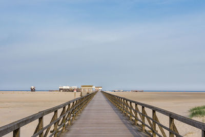 Empty walkway leading to pier