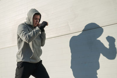 Low angle view of man standing against wall