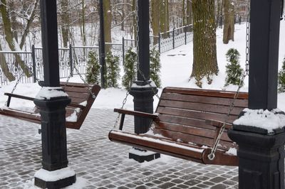 Empty chairs and table in park during winter