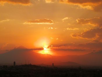 Silhouette buildings against sky during sunset