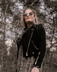 Midsection of woman standing by tree in forest