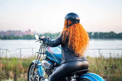 Rear view of woman riding bicycle on water