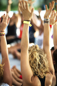 Friends with arms raised enjoying at event