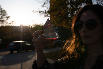 Close-up of woman holding quartz while standing on street