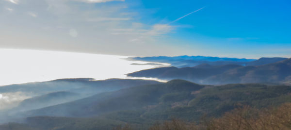 Scenic view of mountains against cloudy sky