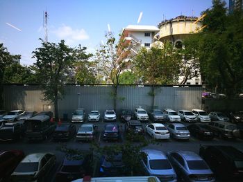 Cars in parking lot by buildings in city