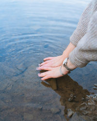 High angle view of woman hand by sea