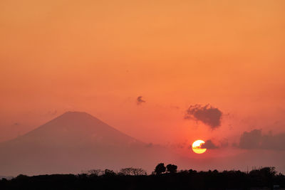 Scenic view of silhouette mountain against orange sky