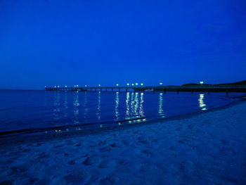 Scenic view of sea against clear blue sky at night