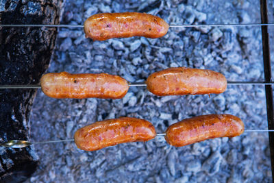 Fried sausages on skewers. summer evenings near the fire, good weekend. close-up