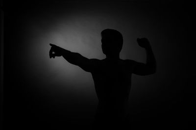 Silhouette of man with arms raised