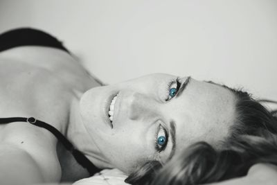 Close-up portrait of woman lying down on bed