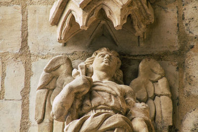 Low angle view of statue against historic building