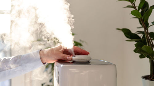 Close-up of woman using humidifier at home