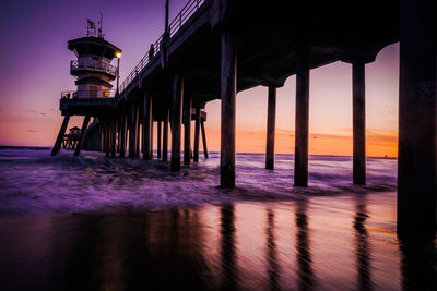 Pier over sea against sky during sunset