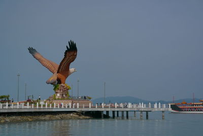 View of birds flying over sea against clear sky