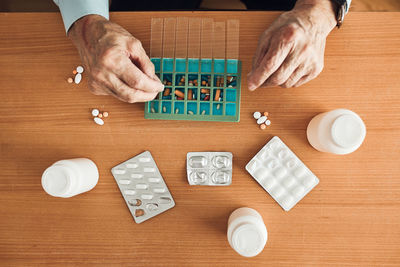 Senior man organizing his medication into pill dispenser. senior man taking pills from box