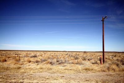 Electricity pylon on field against sky