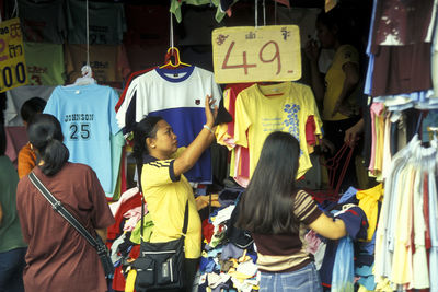 Rear view of people standing on street market