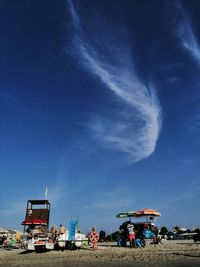 People on beach against blue sky