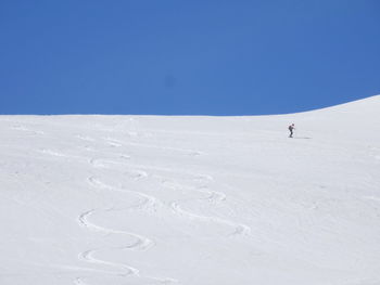 Scenic view of snowcapped landscape against clear blue sky