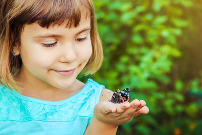 Close-up of girl holding insect