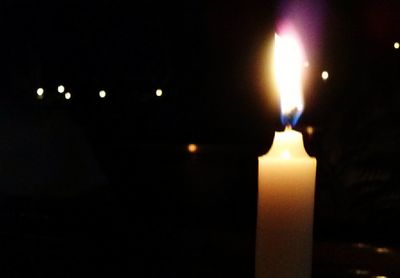 Close-up of lit candle in dark room