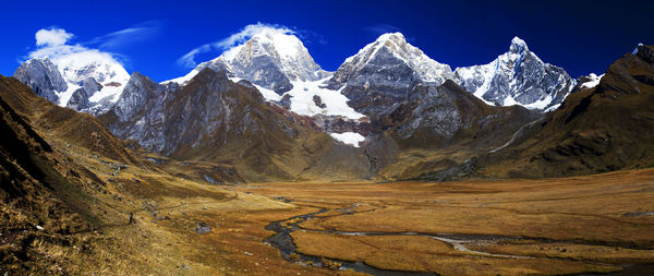 Panorama of snowy mountains and valley of rivers in the remote cordillera huayhuash circuit in peru.