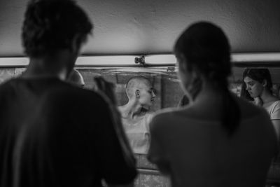 Rear view of man looking through window