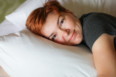 Portrait of woman lying on bed at home