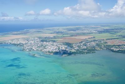 Aerial view of sea and city against sky