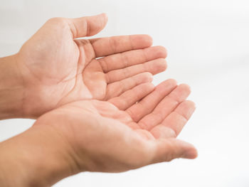 Close-up of hands cupped over white background