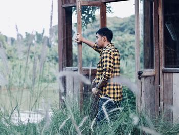 Young man sitting on window